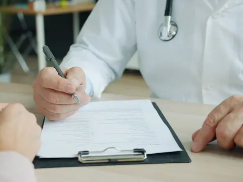 Patient and clinician going over a form at a desk