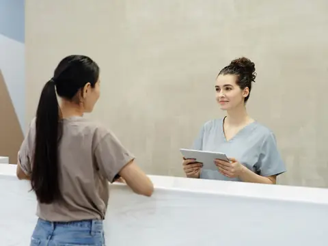 Patient checking in at a bright clinic reception desk